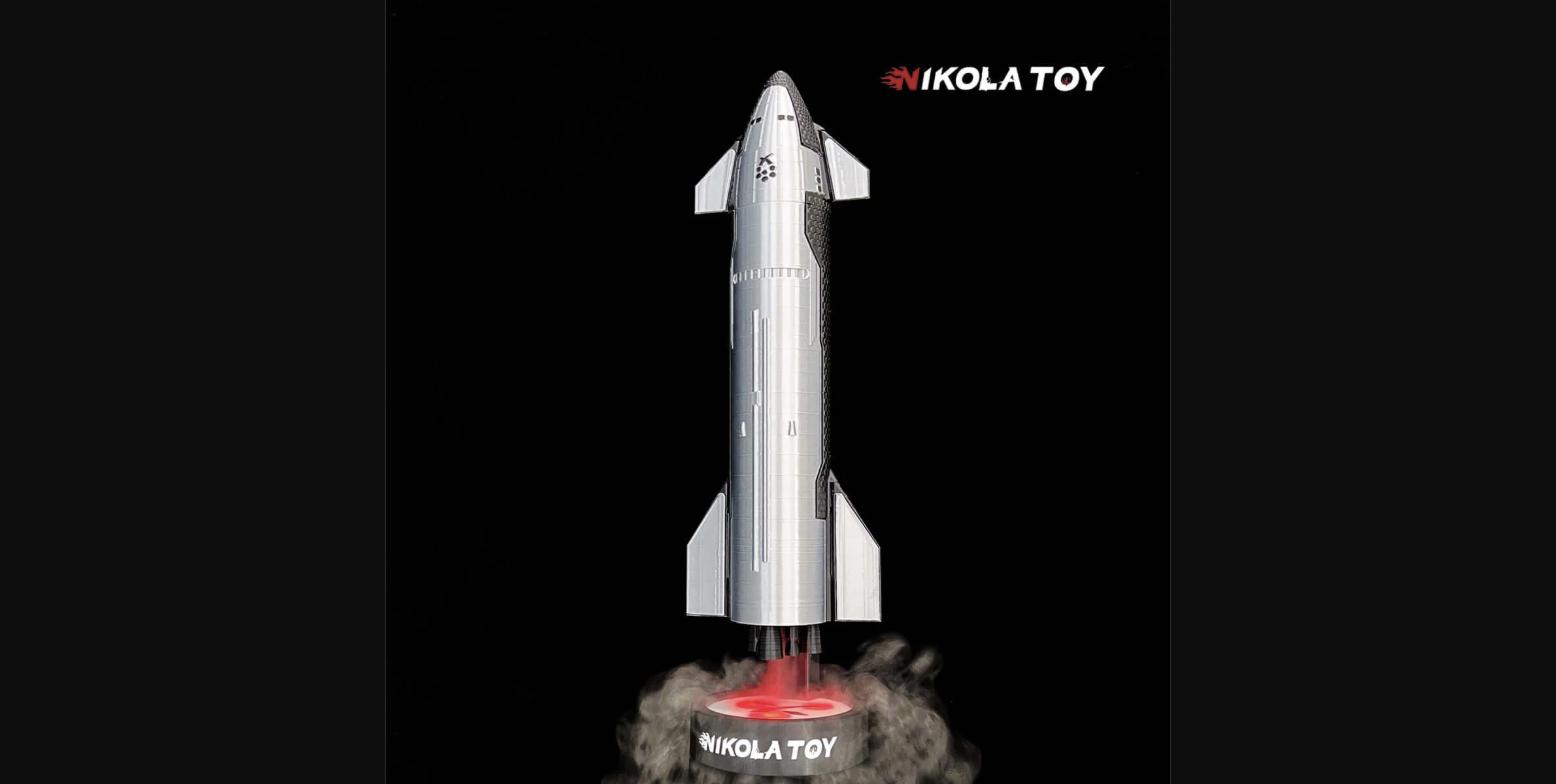 NikolaToy SpaceX Starship model with humidifier active — mist and red glow emanate from the Raptor engine cluster base, replicating the launch plume effect on a desktop scale.